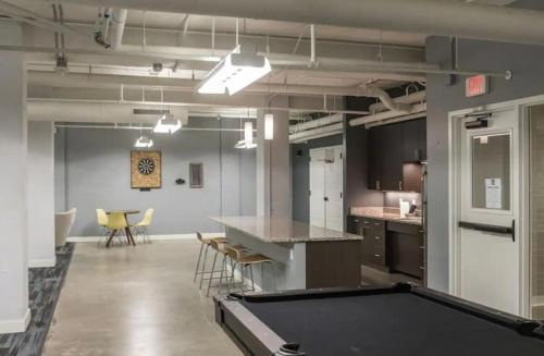 a pool table in a large room with a kitchen at Beautiful 2BR2BA in Bldg connected to Skywalk in Des Moines