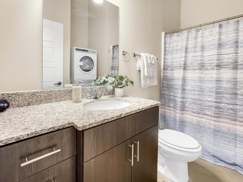 a bathroom with a sink and a toilet and a shower at Stunning Downtown Studio With Rooftop Patio in Des Moines
