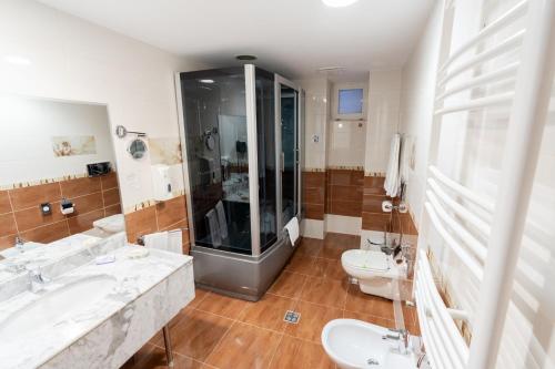 a bathroom with two sinks and a shower and two toilets at Hotel Dorna in Vatra Dornei