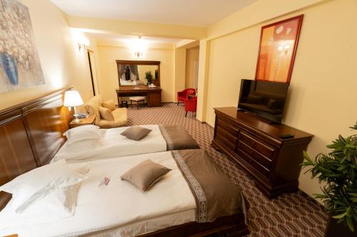 a hotel room with two beds and a television at Hotel Dorna in Vatra Dornei