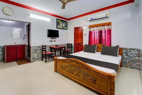 1 dormitorio con cama, mesa y TV en Nestle Inn Near Fortune Tower, en Chennai