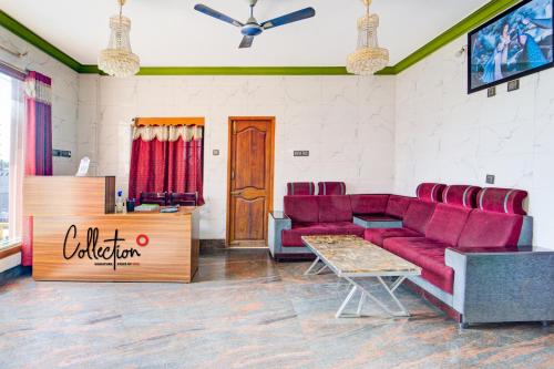 a waiting room with red couches and a table at Nestle Inn Near Fortune Tower in Chennai