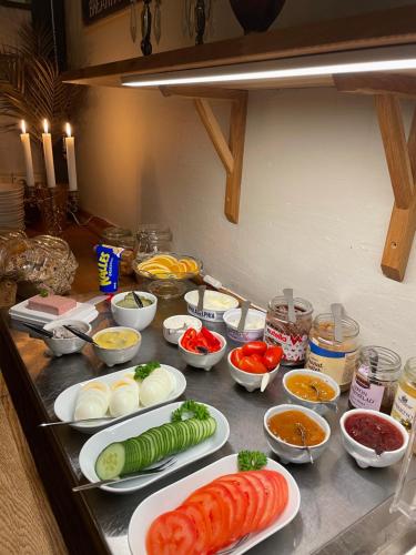 a counter with plates of vegetables and other ingredients at Hotell Briggen i Åhus in Åhus