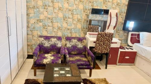 uma sala de estar com um sofá roxo e uma mesa em Hotel V-i sea view, puri private-beach-gym-spa fully-airconditioned-hotel lift-and-parking-facilities breakfast-included em Puri