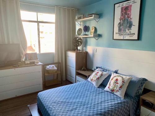 a bedroom with blue walls and a bed with pillows at Apartamento Teatro Conforto no Centro in Curitiba