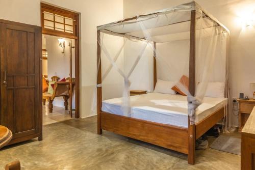 a bedroom with a bed with a canopy at Villa Milla Walauwa in Matale