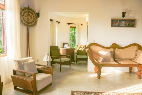 a living room with several chairs and a table at Villa Milla Walauwa in Matale
