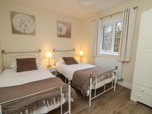 a bedroom with two beds and a window at Country Cottage in Brecon