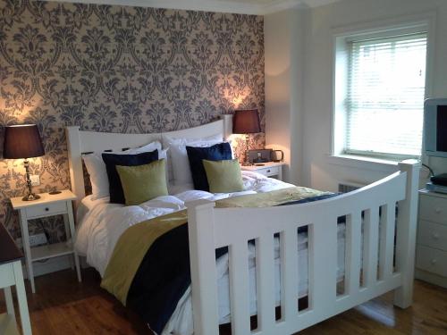 a bedroom with a white bed with pillows at Bruach Lodge in Balloch