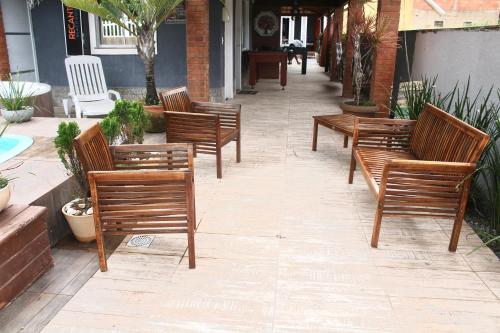 a row of wooden benches sitting on a sidewalk at Pousada Recanto Beach House - Cabo Frio - Unamar in Tamoios