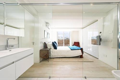 a bedroom with a bed and a sink and a mirror at Modern & Luxurious Seaside Apartment in Cape Town