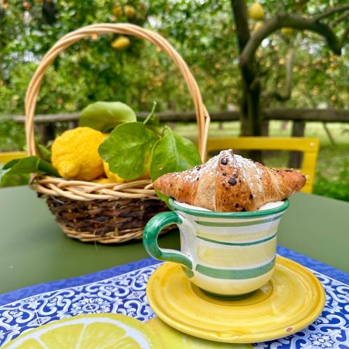 uma xícara sobre a mesa com uma cesta de frutas em Relais Correale Rooms & Garden em Sorrento