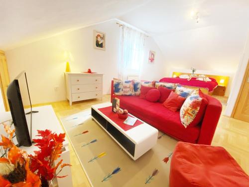 a living room with a red couch and a bed at Villa Mar Vintage Apartments in Dubrovnik