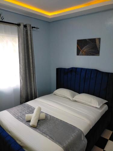 a bedroom with a bed with a stuffed animal on it at Greenstar Homes in Kisii