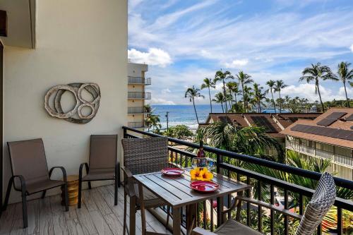 a balcony with a table and chairs and the ocean at Kona Alii 512 in Kailua-Kona