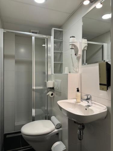 y baño con aseo, lavabo y ducha. en Hotel Titus City Centre en Ámsterdam