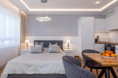 1 dormitorio con 1 cama y 1 mesa con sillas en Helikon Apartman Keszthely, en Keszthely