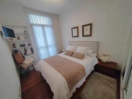 Un dormitorio con una cama grande y una ventana en Habitación con baño privado en el centro de Bilbao, en Bilbao