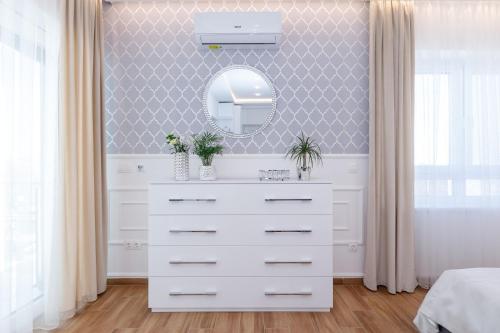 a bathroom with a white dresser and a mirror at Helikon Apartman Keszthely in Keszthely