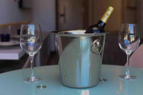 a bottle of wine in a bucket with two wine glasses at Flat 207 Villa del Porto in Porto De Galinhas