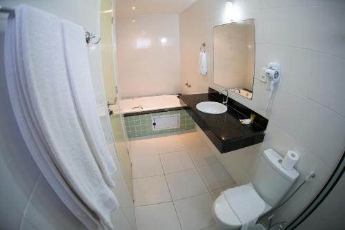La salle de bains est pourvue de toilettes, d'un lavabo et d'un miroir. dans l'établissement Araras Praia Hotel, à Aracaju