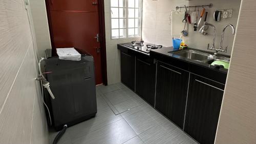 a small kitchen with a sink and a refrigerator at Eehome in Ipoh