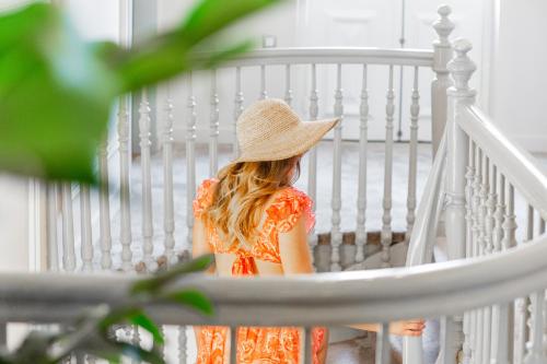 a woman in an orange dress and hat sitting in a crib at King Othon Boutique Hotel in Nafplio