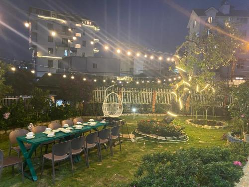 a long table with chairs in a garden at night at Trà My Villa Đà Lạt BBQ Garden in Da Lat