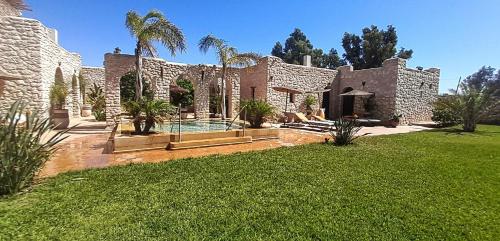 ein Steinhaus mit einem Pool im Hof in der Unterkunft Riad Mamy Wababi in Essaouira
