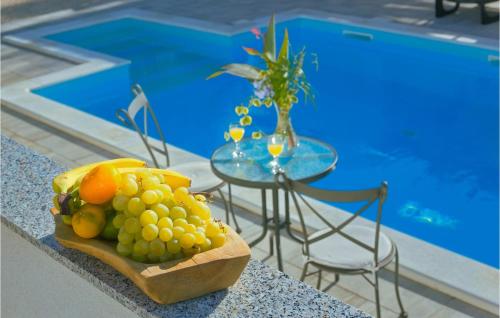 a bowl of fruit on a table next to a pool at Stunning Home In Lun With Wifi in Lun