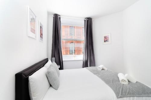 una camera con un letto bianco e una finestra di Covent Garden Central Apartments a Londra