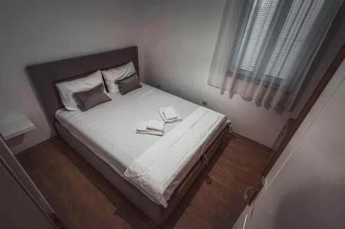 Un dormitorio con una cama con dos libros. en Apartment Podgorica Center, en Podgorica
