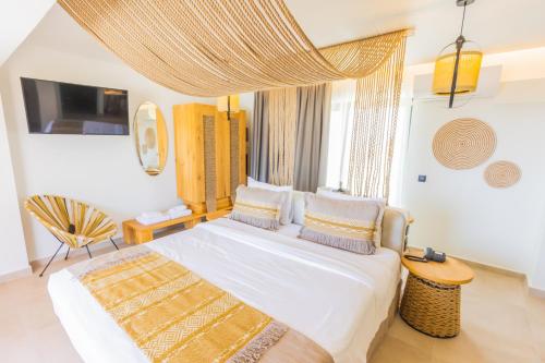 a bedroom with a large bed with white sheets and pillows at Cabana Blu Hotel & Suites in Kardamaina