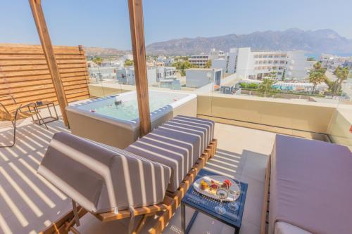 a balcony with chairs and a hot tub on a roof at Cabana Blu Hotel & Suites in Kardamaina