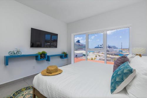 a bedroom with a large bed with a flat screen tv at Aruba Dreams, Take Me Away Studio in Oranjestad