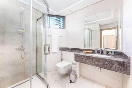 a bathroom with a shower and a toilet and a sink at Manzil - 1BR in The Bay with Canal View nr Dubai Mall in Dubai