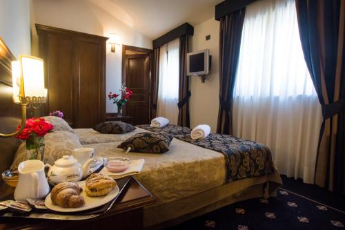 a hotel room with two beds with a tray of food at Antica Stazione in Chiaramonte Gulfi