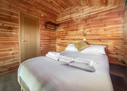 a bedroom with a bed in a wooden wall at Lakeside Fishing Retreats in Old Leake