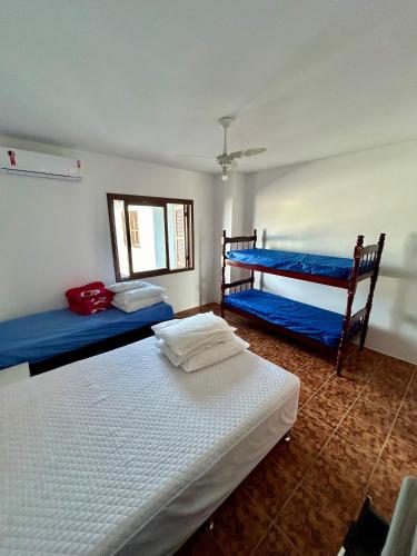 a bedroom with two bunk beds and a window at Residencial Raupp in Capão da Canoa