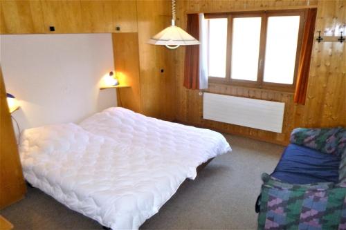 een slaapkamer met een wit bed en een raam bij Bellevue L 031 - PLEASANT apartment 6 pers in Veysonnaz