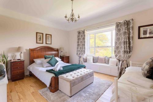 a bedroom with a bed and a couch and a window at Mount Eagle - Sleeps 24 in Limerick