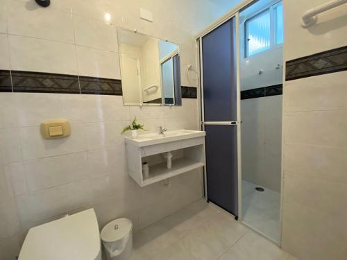 a bathroom with a toilet and a sink and a shower at Apartamento 1 quadra do mar in Pontal do Paraná