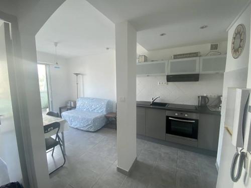une cuisine et un salon avec une table et un canapé dans l'établissement BEL APPARTEMENT P2 - CENTRE VILLE - BORD DE MER, à La Grande Motte