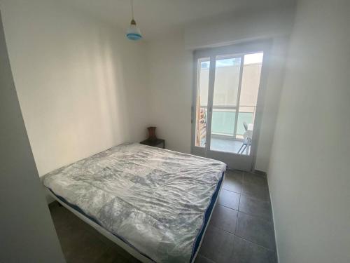 une petite chambre avec un lit et une fenêtre dans l'établissement BEL APPARTEMENT P2 - CENTRE VILLE - BORD DE MER, à La Grande Motte