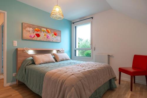a bedroom with a bed and a window and a red chair at Ty Melen Glaz - 200m de la plage in Bénodet