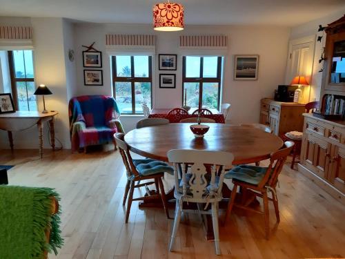 a living room with a wooden table and chairs at Stone fronted detached cottage just over 2 miles from Mulranny village in Mulranny