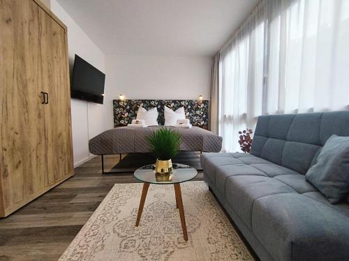 een woonkamer met een bank en een bed bij Design-Apartment für bis zu 4 im 1 OG, modern, Dachterrasse, Grill, ruhige Lage, Disney plus, Wii, LAN und WLAN in Neurenberg
