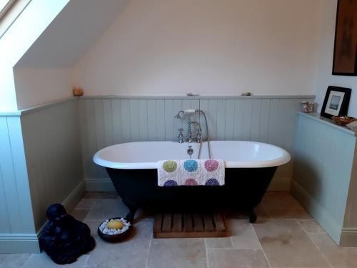 a bathroom with a black and white bath tub at Stone fronted detached cottage just over 2 miles from Mulranny village in Mulranny