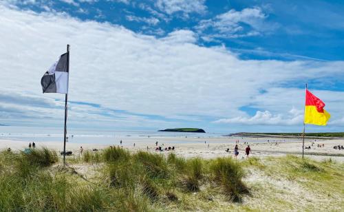 two flags on a beach with people on the beach at Stone fronted detached cottage just over 2 miles from Mulranny village in Mulranny