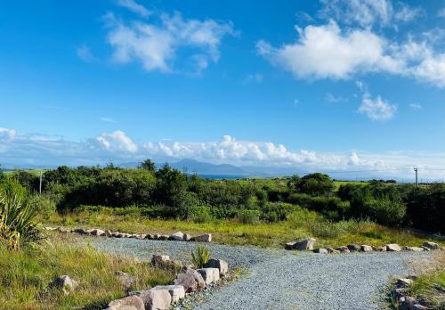 a gravel road with rocks on the side of a field at Stone fronted detached cottage just over 2 miles from Mulranny village in Mulranny